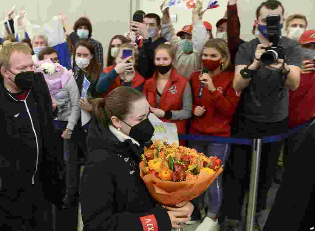 Kamila Valieva, la atleta del Comité Olímpico Ruso camina, aplaudida por sus simpatizantes en el aeropuerto internacional Sheremetyevo en las afueras de Moscú, a su regreso de los Juegos de Beijing 2022.