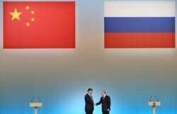 FILE - Russian President Vladimir Putin, right, and Chinese President Xi Jinping shake hands at the opening ceremony of the Year of Chinese tourism in Russia, in the Kremlin in Moscow, Friday, March 22, 2013.