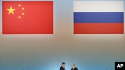 El presidente ruso, Vladimir Putin, a la derecha, y el presidente chino, Xi Jinping, se dan la mano en la ceremonia de apertura del Año del turismo chino en Rusia, en el Kremlin de Moscú, el 22 de marzo de 2013.