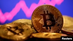 FILE - A representation of virtual currency bitcoin is seen in front of a stock graph in this illustration taken Jan. 8, 2021.