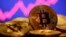 FILE - A representation of virtual currency bitcoin is seen in front of a stock graph in this illustration taken Jan. 8, 2021.