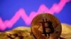 FILE - A representation of virtual currency bitcoin is seen in front of a stock graph in this photo illustration created Jan. 8, 2021. The value of bitcoin, the most popular form of cryptocurrency, has dropped more than 70% since its peak in November of last year.