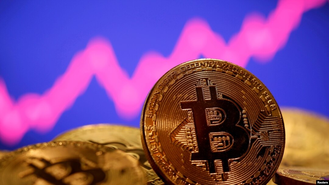 FILE - A representation of virtual currency bitcoin is seen in front of a stock graph in this illustration taken Jan. 8, 2021.