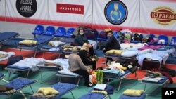 Civiles desplazados de las regiones de Donetsk y Luhansk, el territorio controlado por los gobiernos separatistas prorrusos en el este de Ucrania, descansan en un pabellón deportivo en Taganrog, Rusia, el lunes 21 de febrero de 2022.