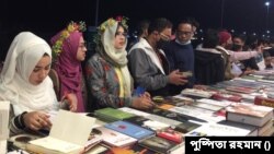 বইমেলার স্টলে সাজানো বই থেকে পছন্দের বই বাছাই করছেন গ্রন্থানুরাগীরা। ১৭ ফেব্রুয়ারি। 