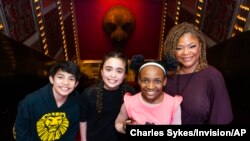 Vince Ermita, from left, Alayna Martus, Sydney Elise Russell and Bonita J. Hamilton pose in the lobby of the Minskoff Theatre before a performance of Broadway's 'The Lion King' on Feb. 18, 2022, in New York.