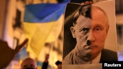 Người biểu tình ở Barcelona, Tây Ban Nha, giương cờ Ukraine và hình ảnh ghép nhà lãnh đạo Nga Vladimir Putin và nhà độc tài phát xít Adolf Hitler 