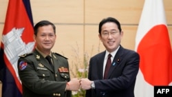 Hun Manet (L), Commander of the Royal Cambodian Army and who is the elder son of Cambodian Prime Minister Hun Sen, fist bumps with Japan's Prime Minister Fumio Kishida at the start of their meeting at the Prime Minister's official residence in Tokyo on February 16, 2022.