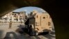 FILE - US-backed Syrian Democratic Forces (SDF) fighters stand guard at Al Naeem Square, in Raqqa, Syria, Feb. 7, 2022. 