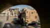 FILE - U.S.-backed Syrian Democratic Forces (SDF) fighters stand guard at Al Naeem Square, in Raqqa, Syria, Feb. 7, 2022. 