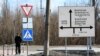 A man walks past a road sign in the town of Avdiivka, Donetsk region, located on the front-line with Russia-backed separatists, Feb. 21, 2022.