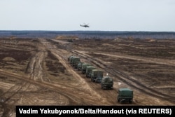 A helicopter flies over troops during the joint military drills of the armed forces of Russia and Belarus at a firing range in the Brest Region, Belarus. Feb. 19, 2022.