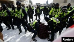 Police officers detain a man, as truckers and supporters protest COVID-19 vaccine mandates, in Ottawa, Ontario, Canada, Feb. 18, 2022.