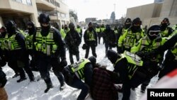 Police officers detain a man, as truckers and supporters protest COVID-19 vaccine mandates, in Ottawa, Ontario, Canada, Feb. 18, 2022. 