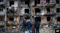 Люди смотрят на ущерб, нанесенный в результате ракетного обстрела города Киева, Украина, 25 февраля 2022