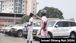 Lilian Essono et Roy Maganga, deux jeunes gardiens de parking auto à Libreville, au Gabon.(VOA/Ismael Obiang Nzé)