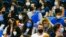Fans wearing face masks watch a college basketball game in Los Angeles, Feb. 17, 2022.