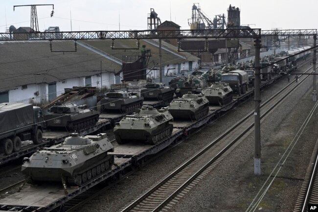 Kendaraan lapis baja Rusia dimuat ke platform kereta api di stasiun kereta api di wilayah tidak jauh dari perbatasan Rusia-Ukraina, di wilayah Rostov-on-Don, Rusia, Rabu, 23 Februari 2022. (Foto: AP)