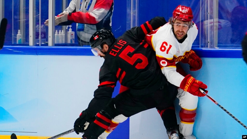 2022年2月15日，在2022年北京冬奥会男子冰球预选赛中，中国选手韦瑞克（61号）被加拿大选手摩根·埃利斯(5号)挡住。(photo:VOA)