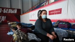 A woman and child rest at a temporary accommodation center for evacuees from the separatist-controlled regions of eastern Ukraine, which is located at a local sports school in the city of Taganrog in the Rostov region, Russia Feb. 21, 2022.