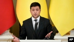Ukrainian President Volodymyr Zelenskyy gestures while speaking during a joint news conference with Polish President Andrzej Duda and Lithuania's President Gitanas Nauseda following their talks at The Mariinskyi Palace in Kyiv, Ukraine, Feb. 23, 2022.