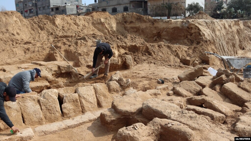 Men work in a newly discovered Roman cemetery in Gaza, in this handout photo obtained by Reuters, February 17, 2022. Ministry of Tourism and Antiquities/Handout via REUTERS 