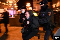24일 러시아 수도 모스크바 시내에서 우크라이나 침공 항의 시위 참가자(가운데)가 경찰에 연행되고 있다.