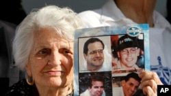 Eva Barba, madre de Pablo Morales (abajo a la derecha), uno de los pilotos de Hermanos al Rescate derribados por los MIG cubanos, muestra una foto de los cuatro pilotos fallecidos. Marcha por la libertad de Cuba en Miami, el jueves 2 de febrero de 2019.