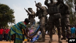 A woman lays flowers at the base of a monument to Central African soldiers and Russian armed men, in Bangui, Central African Republic, Feb. 23, 2022.