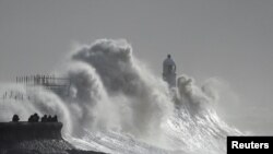 Ombak menerjang mercusuar di wilayah Porthcawl, Wales, saat badai Franklin menerjang Inggris dan Wales, pada 21 Februari 2022. (Foto Reuters/Rebecca Naden)