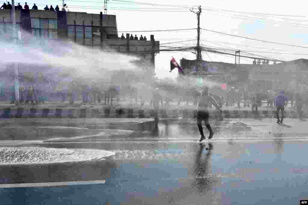Police use water cannons to break up demonstrators during a protest against the proposed grant agreement from America under the Millennium Challenge Corporation (MCC), in Kathmandu, Nepal.