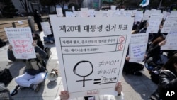 A protester holds a sign reading 'The 20th Presidential Election Vote' at a rally supporting feminism in Seoul, South Korea, Feb. 12, 2022.