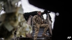 A Ukrainian serviceman stands at his position at the line of separation between Ukraine-held territory and rebel-held territory near Svitlodarsk, eastern Ukraine, Feb. 23, 2022.