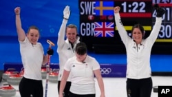 Team Britain celebrates after winning the women's curling semifinal match between Britain and Sweden at the Beijing Winter Olympics, in Beijing, Feb. 18, 2022.