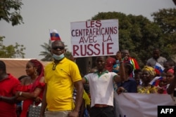 A man holds a pro-Russian placard reading "Centrafricans with Russia," during a pro-Russia rally in Bangui, Central African Republic, Feb. 23, 2022.