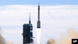 FILE - A Long March-2F Y12 rocket carrying a crew of Chinese astronauts in a Shenzhou-12 spaceship lifts off at the Jiuquan Satellite Launch Center in Jiuquan, China, June 17, 2021.
