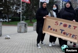 Aksi protes para pendukung tim sepakbola perempuan "Les Hijabeuses" di depan balai kota di Lille, Prancis, 16 Februari 2022. Slogan itu berbunyi "Olahraga untuk semua". (REUTERS/Pascal Rossignol)