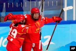 China's Mi Le (Hannah Miller) (34) celebrates with Wang Yuting (49) after scoring a goal against Czech Republic during a preliminary round women's hockey game at the 2022 Winter Olympics, Feb. 3, 2022, in Beijing.