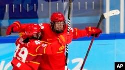 2022年2月3日，在2022年北京冬奥会上的女子冰球预选赛中，中国选手米勒(汉娜·米勒)(34号)和王玉婷(49号)在对阵捷克的比赛中进球后进行庆祝。