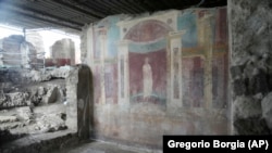 A wall painting, or fresco, shows a poet at the Pompeii archaeological site, Feb. 15, 2022. (AP Photo/Gregorio Borgia)