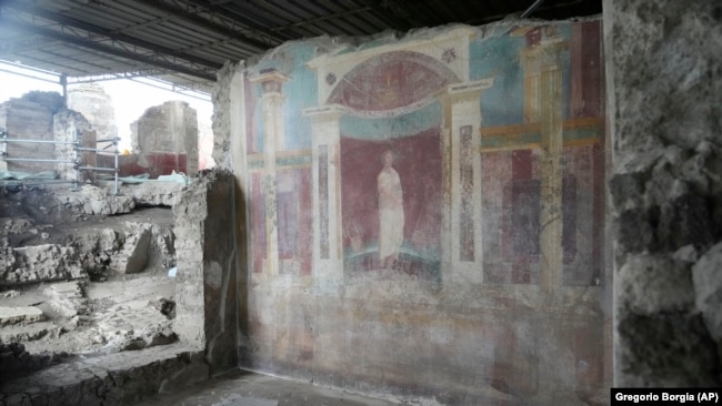 A wall painting, or fresco, shows a poet at the Pompeii archaeological site, Feb. 15, 2022. (AP Photo/Gregorio Borgia)