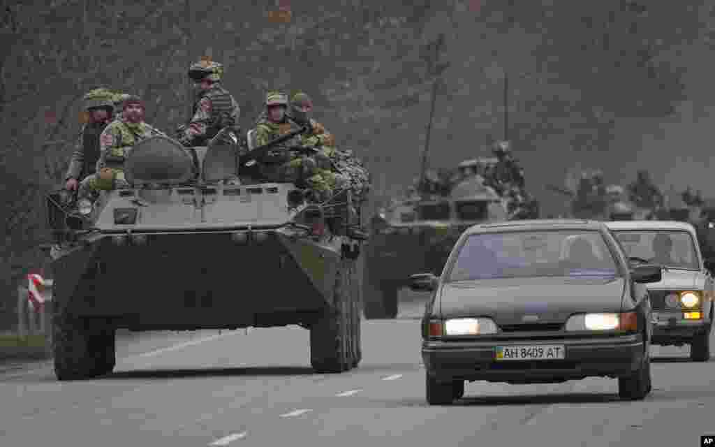 Militares ucranianos sentados encima de vehículos blindados de transporte de personal que conducen por una carretera en la región de Donetsk, en el este de Ucrania.