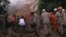 Firefighters and volunteers shovel away mud from a giant landslide in the Caxambu neighborhood in Petropolis, Brazil, Feb. 19, 2022.
