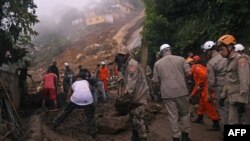 FILE: Firefighters and volunteers shovel away mud from a giant landslide in the Caxambu neighborhood in Petropolis, Brazil, Feb. 19, 2022.