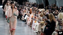 Bella Hadid, leads other models, as they wear creations as part of the Fendi Fall/Winter 2022-2023 fashion collection, as guests record the show on their cell phones during the Fashion Week in Milan, Italy, Feb. 23, 2022. 