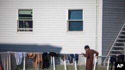 Seorang pengungsi Afghanistan berdiri di luar perumahan sementara di pangkalan Angkatan Darat AS Fort McCoy pada Kamis, 30 September 2021. (Foto: via AP)