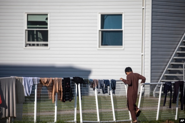 Seorang pengungsi Afghanistan berdiri di luar perumahan sementara di pangkalan Angkatan Darat AS Fort McCoy pada hari Kamis, 30 September 2021 di Fort McCoy, Wisconsin. (Foto: via AP)