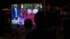 Gente mira la juramentación del presidente Daniel Ortega para un cuarto período consecutivo en una pantalla jugante en un barrio de Managua, Nicaragua, 10 de enero de 2022.