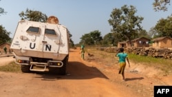 Un véhicule blindé de transport de troupes des Nations Unies patrouille sur une route supposée sûre, évitant les routes avec d'éventuels engins explosifs, à Paoua, en République centrafricaine, le 5 décembre 2021.