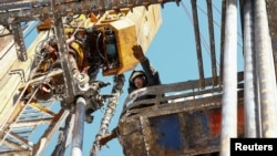 FILE - A drilling crew member works at an oil rig in the Yarakta Oil Field, owned by Irkutsk Oil Company (INK), in Irkutsk region, Russia, March 11, 2019.